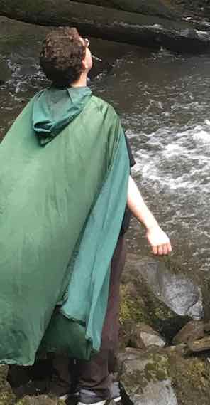 Poorly-cropped picture of me wearing my cloak next to a waterfall